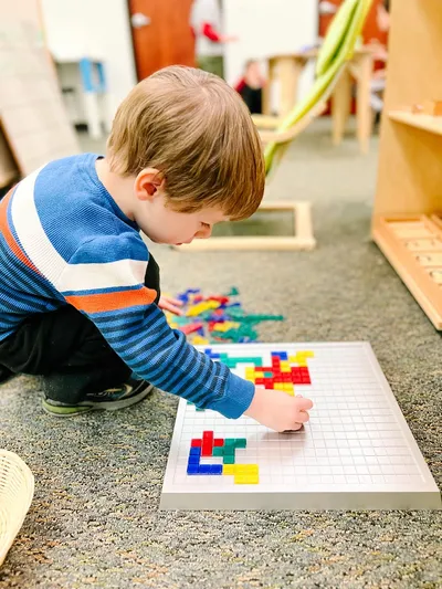 Young boy arranging colorful blocks in The Elementary Studio